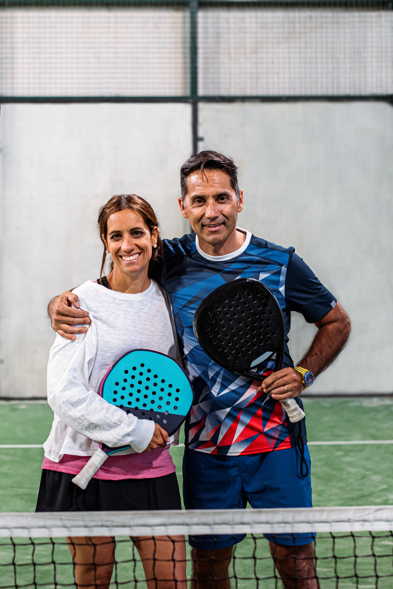 two mixed padel players embracing and looking at camera