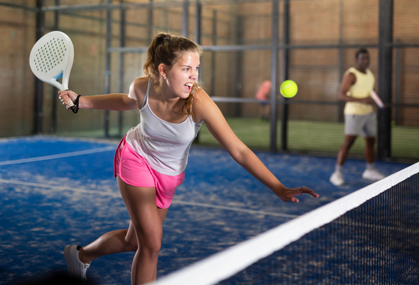 Woman playing padel tennis on padel court